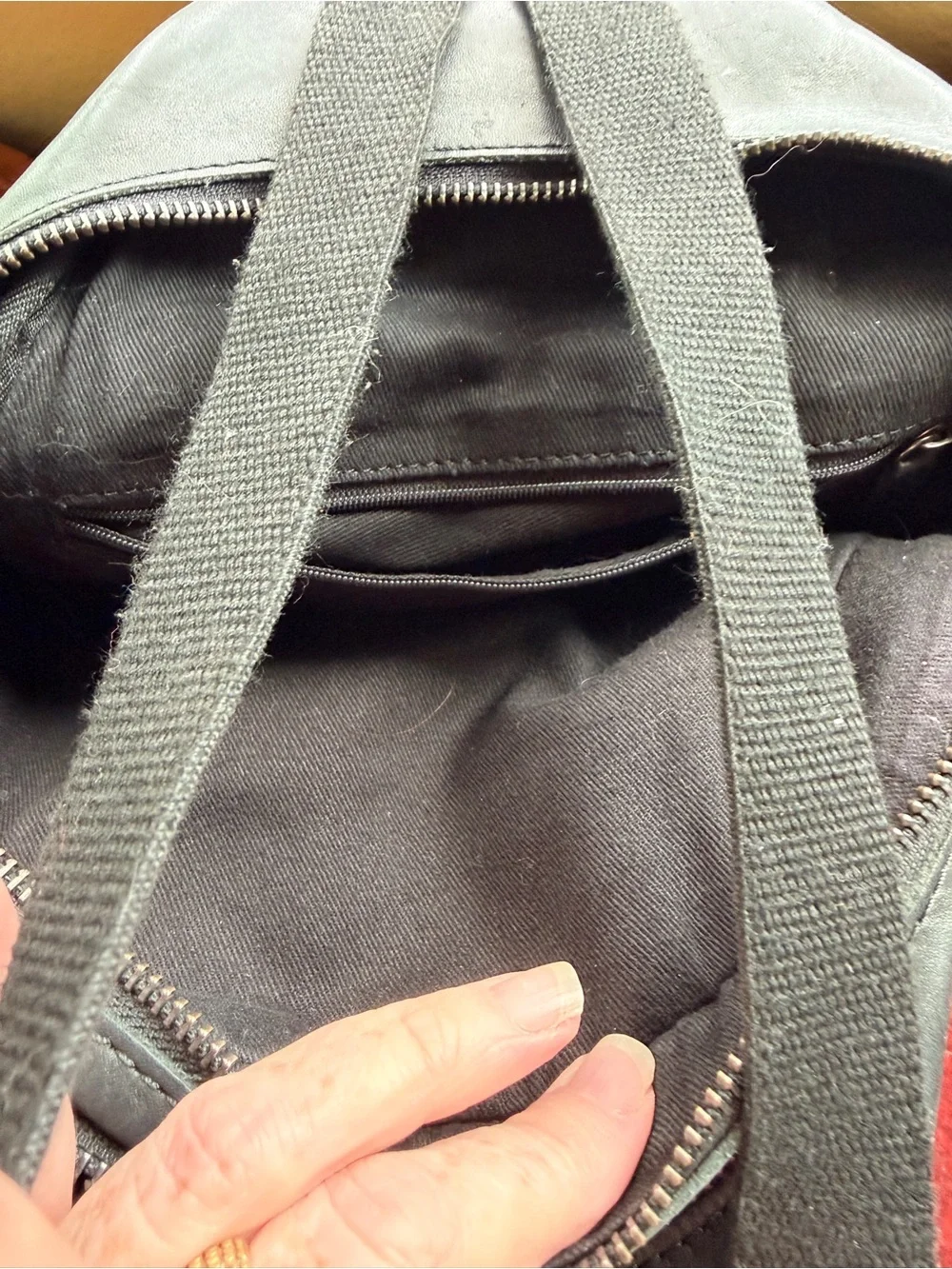 Black trianglular leather backpack with multiple pockets